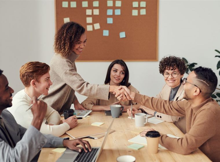 Equipe em reunião de marketing comemorando um acordo