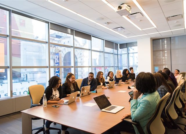 Sala de reunião cheia, equipe apresentando resultados
