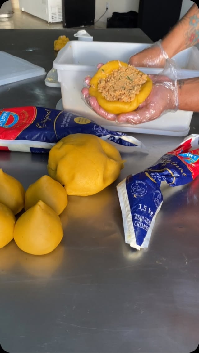 Preparo artesanal: massa sendo recheada à mão na cozinha